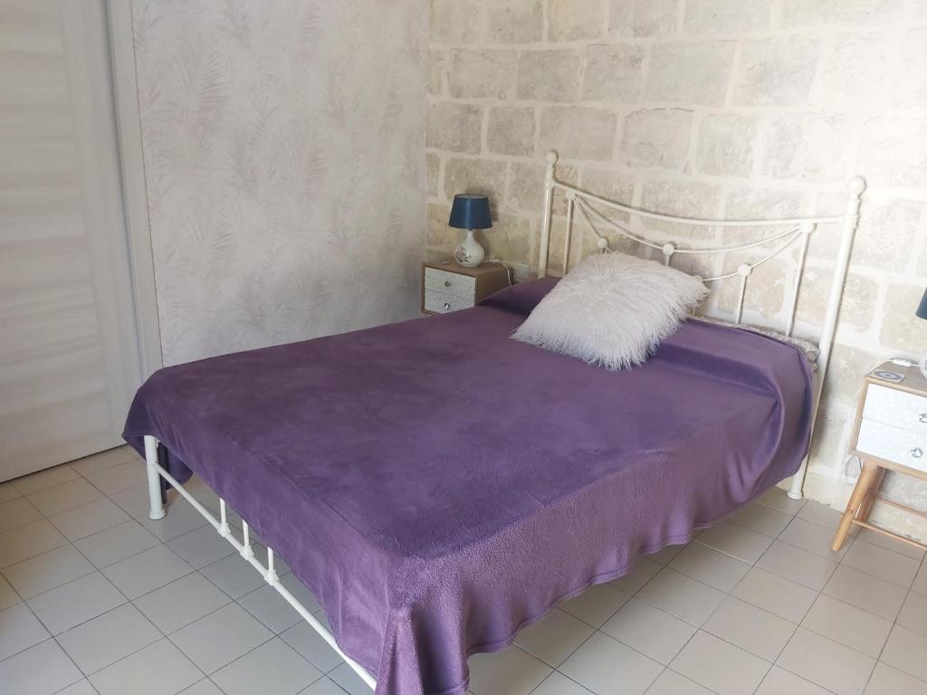 ein Schlafzimmer mit einem Bett mit einer lila Decke in der Unterkunft One bedroom apartment in Qormi