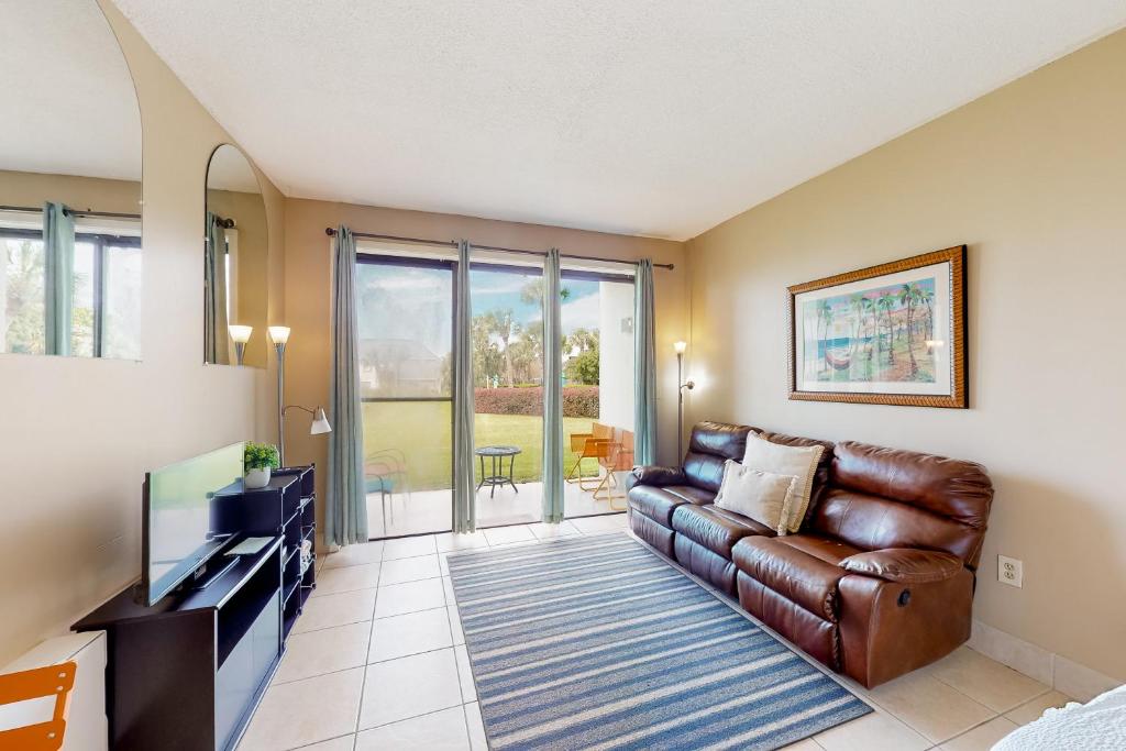 a living room with a leather couch and a television at Pirates Bay A102 in Fort Walton Beach