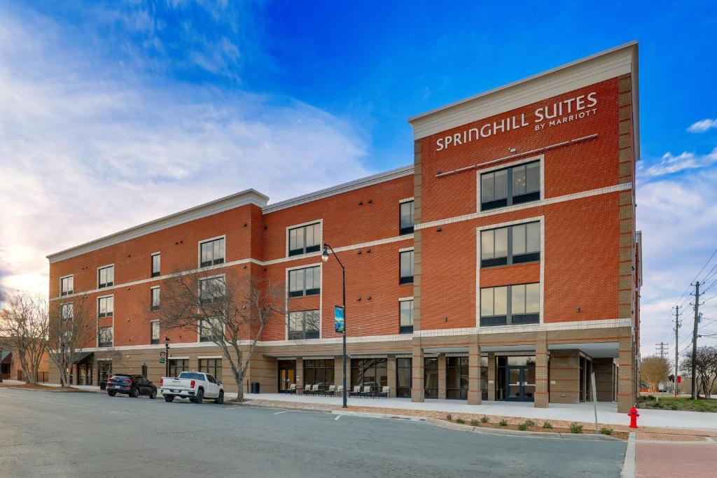 un gran edificio de ladrillo rojo con un cartel. en SpringHill Suites by Marriott Cheraw, en Cheraw