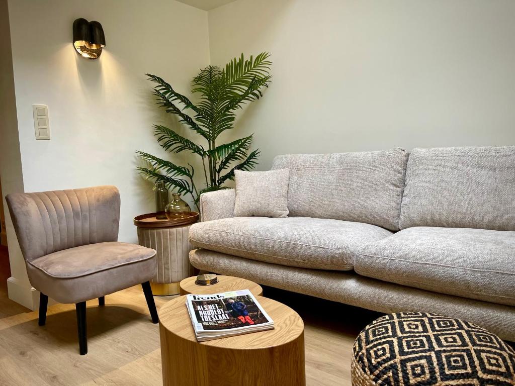 a living room with a couch and a chair at La Porte Rouge - The Red Door in Oudenaarde