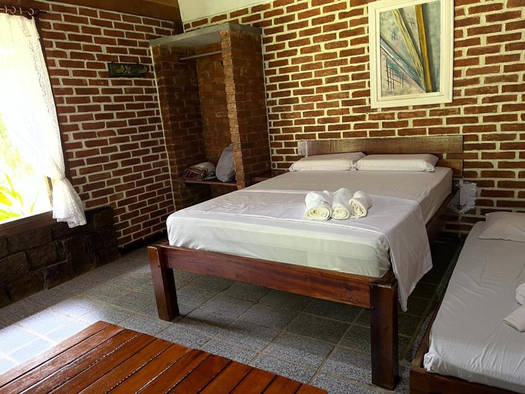 um quarto com uma cama com toalhas em Sitio Serenar Chalés Equipados em Penedo