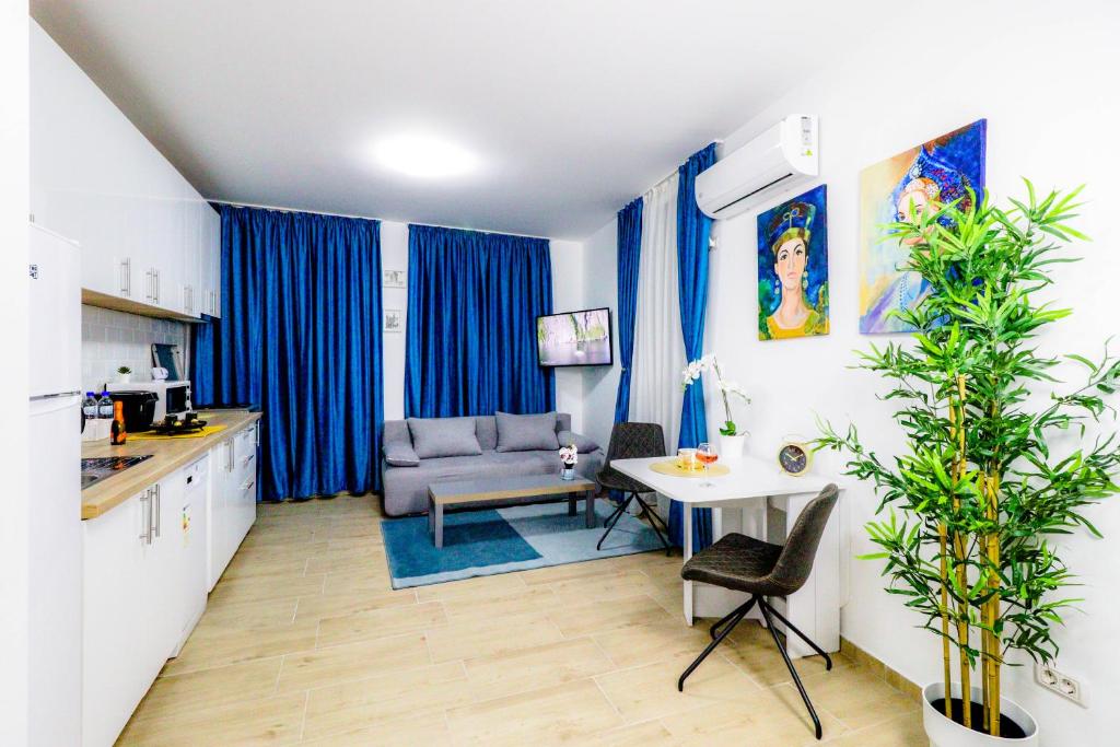 een keuken met blauwe gordijnen en een tafel en een bank bij Modern & Comfortable Apartament Cismigiu Park - POP3 in Boekarest