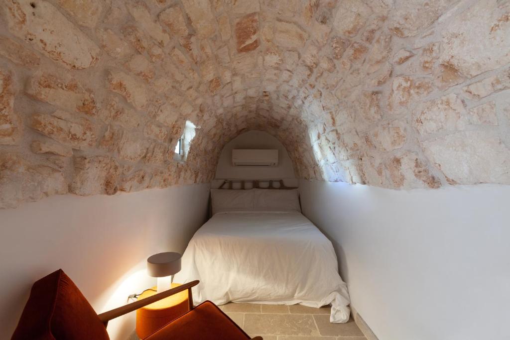 a bedroom with a bed in a stone wall at Casa Antica Pietra Ostuni in Ostuni