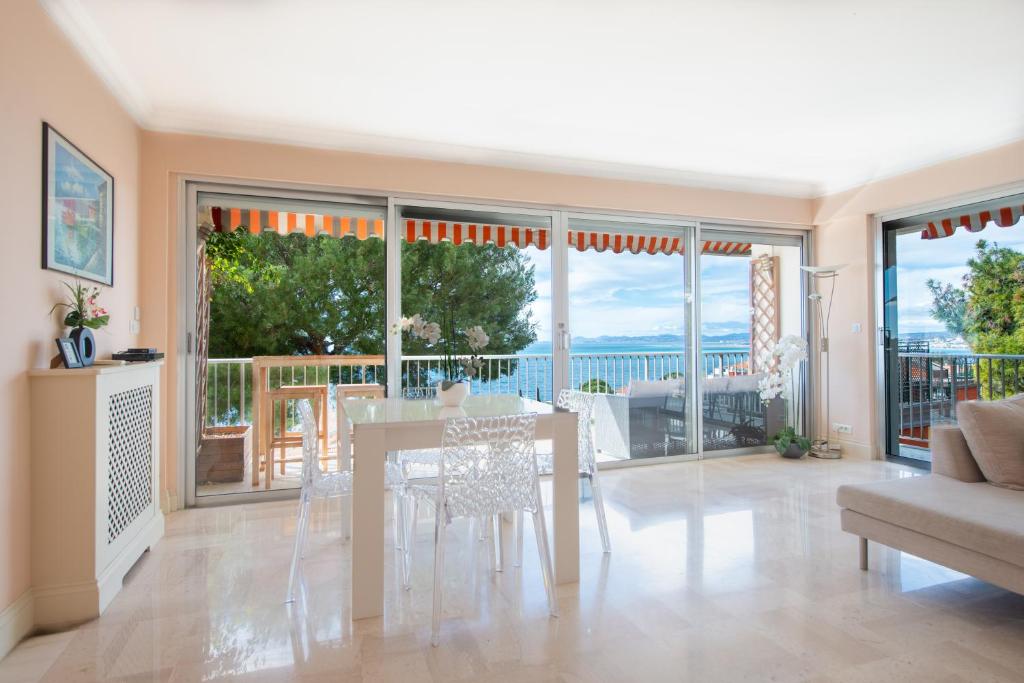 - un salon avec une table, des chaises et des portes coulissantes en verre dans l'établissement PRESTIGE Mont Boron -Terrace -Sea View -2BR, à Nice