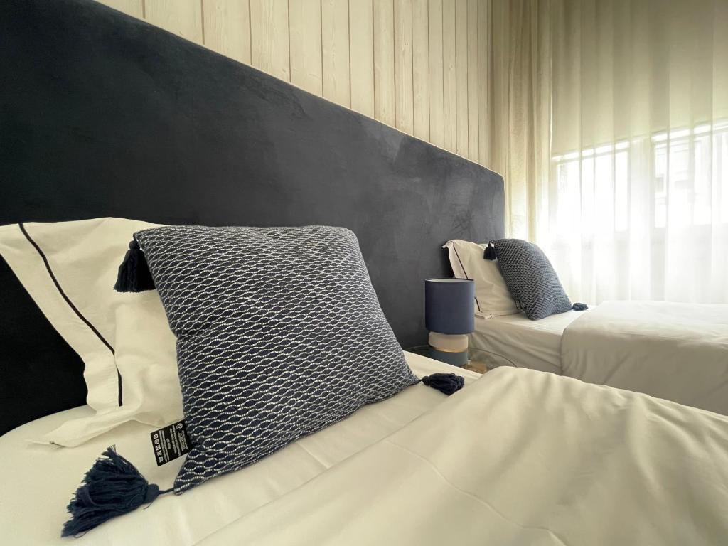 ブラガにあるPORTA NOVA Historic Center - Apartments Collection by Perpetual Relaxのベッド2台と壁のある寝室