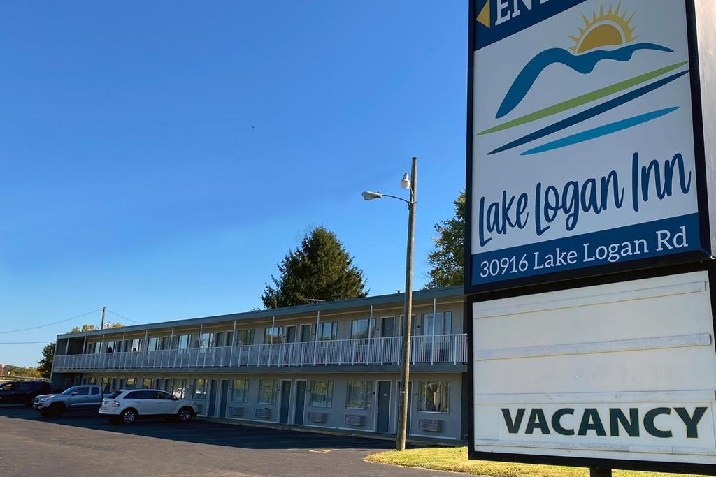 a sign in front of a large building at Lake Logan Inn in Logan