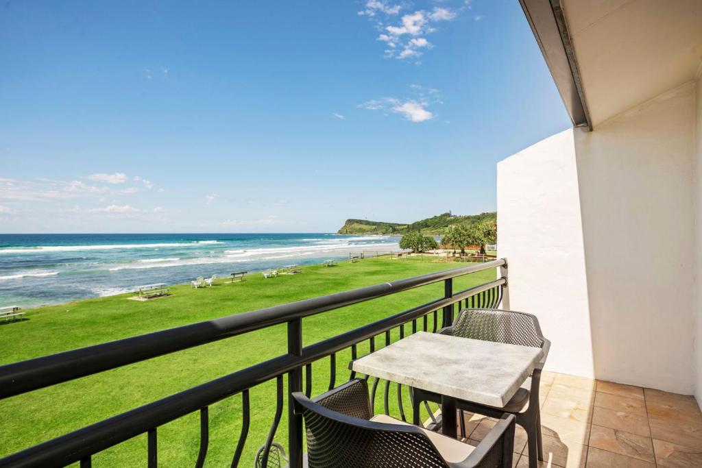 a balcony with a table and chairs and the beach at Apartment 9T in Lennox Head
