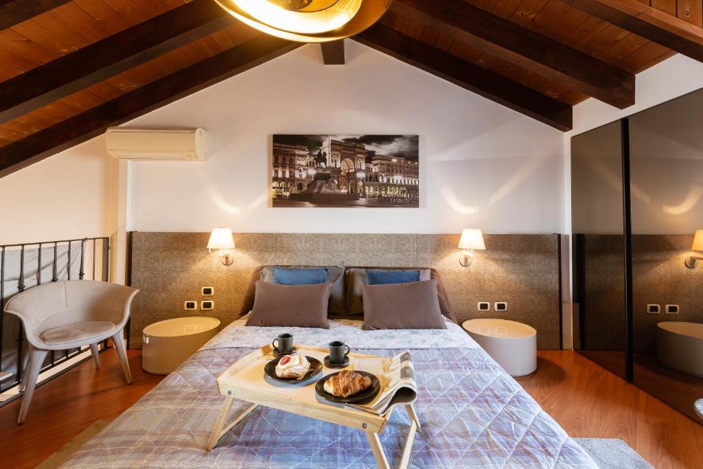 ein Schlafzimmer mit einem Bett und einem Tablett mit Essen drauf in der Unterkunft Casa del Borgo - Esclusiva Suite centro Monza con vista Duomo in Monza