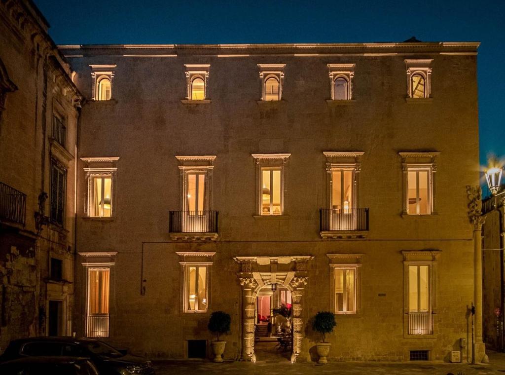 un gran edificio con ventanas iluminadas en una calle en Palazzo Maresgallo Suites & SPA en Lecce