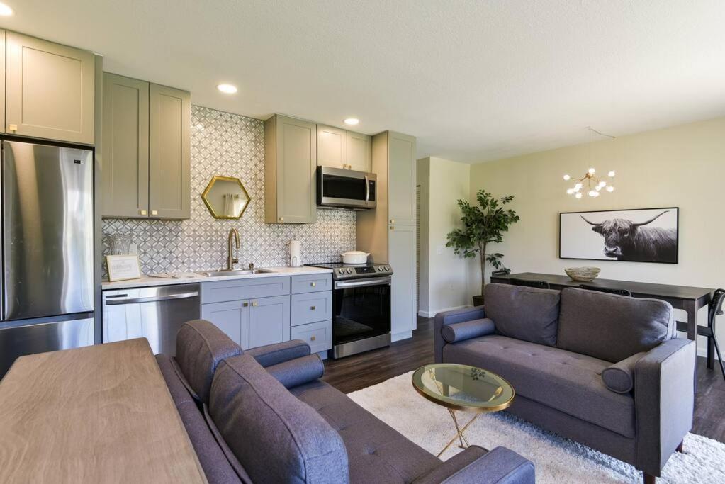 ein Wohnzimmer mit einem Sofa und einer Küche in der Unterkunft Sparkling Designer 3 bed Suite by Taneycomo in Branson