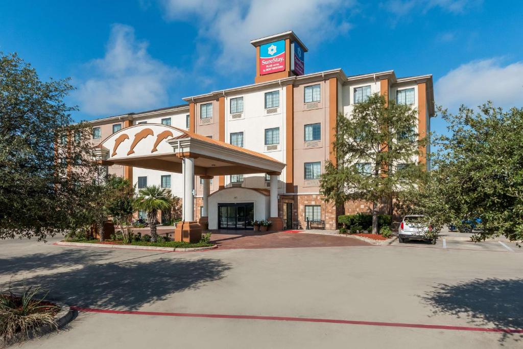 a front view of a hotel with a parking lot at SureStay Plus Hotel by Best Western Near SeaWorld San Antonio in San Antonio