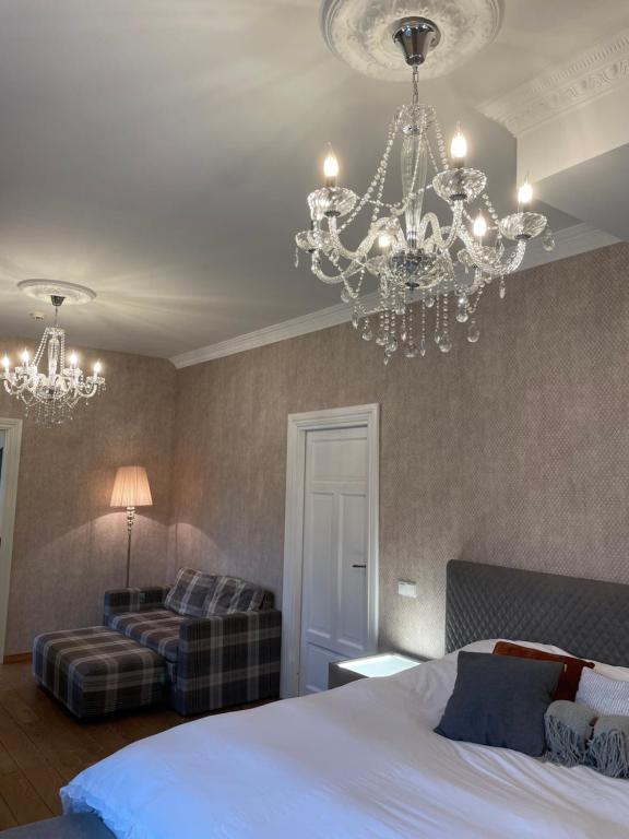 a bedroom with a bed and a chandelier at E & A LOSSI 21/23 in Tartu