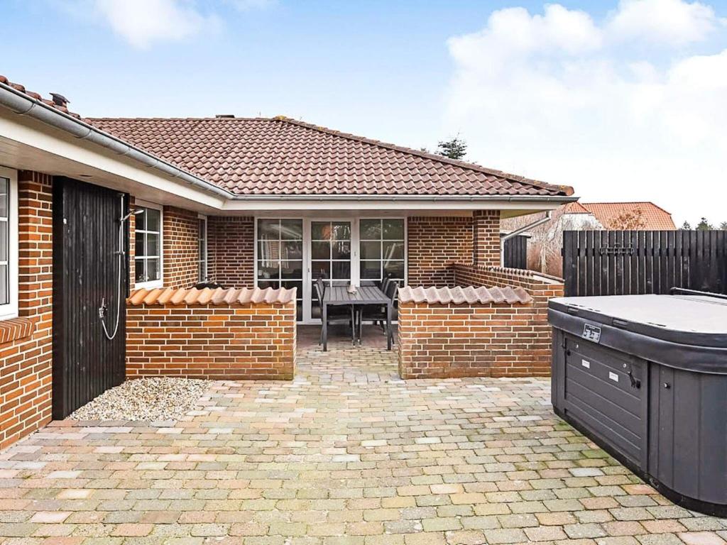 a brick house with a patio with a table at Holiday home Blåvand CCCVIII in Blåvand