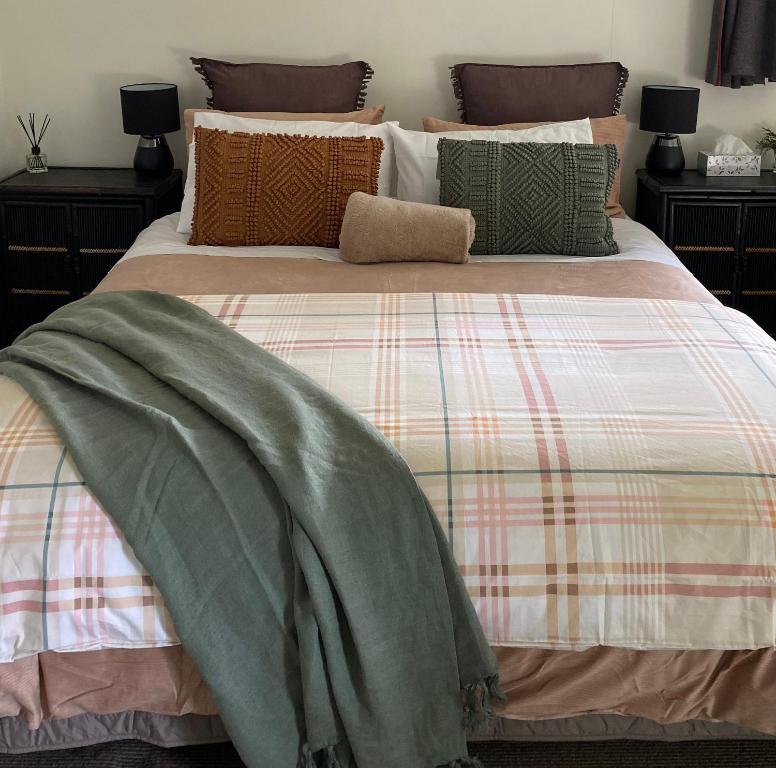 een bed met een deken erop bij Glenie Cottage BnB Guesthouse in Timaru