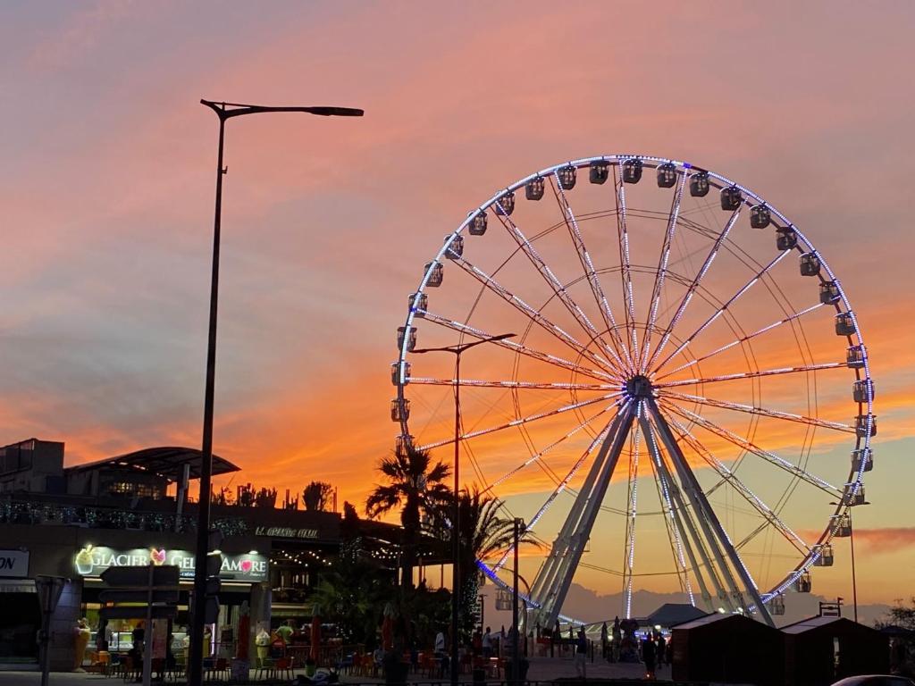 une grande roue dans un parc d'attractions au coucher du soleil dans l'établissement Sun escape, appart rénové climatisé 3 pièces 4-6 pers, 350m de la plage, à Marseille