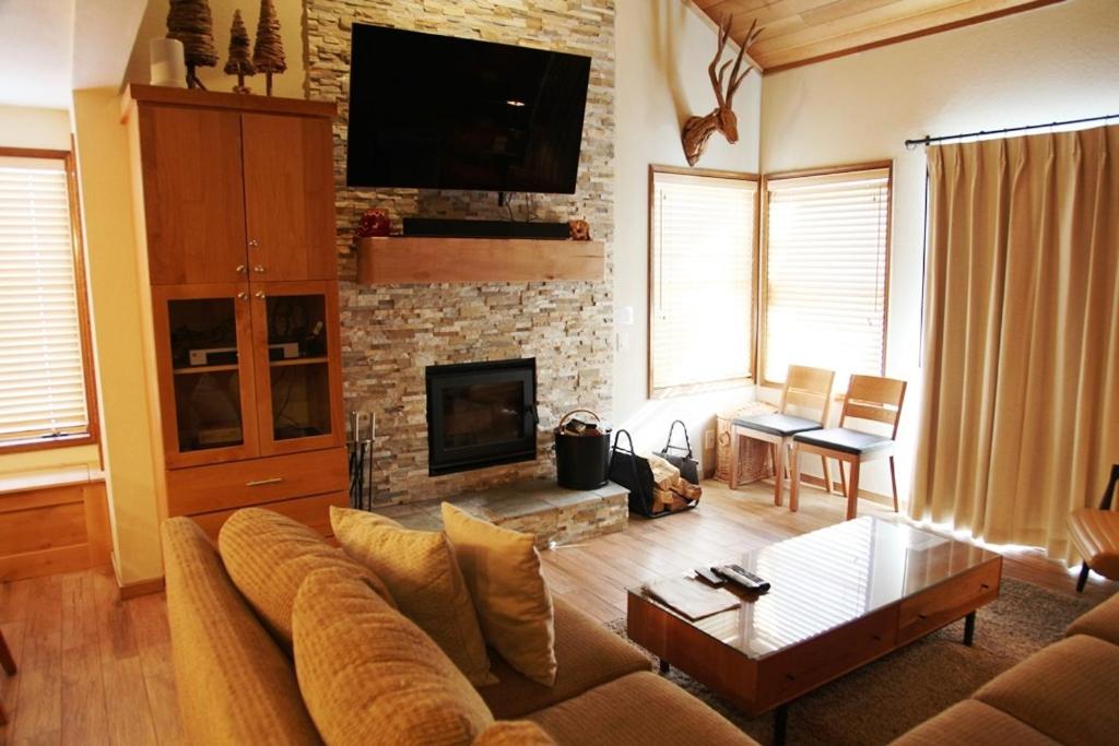 a living room with a couch and a fireplace at Sierra Megeve #7 Condo in Mammoth Lakes