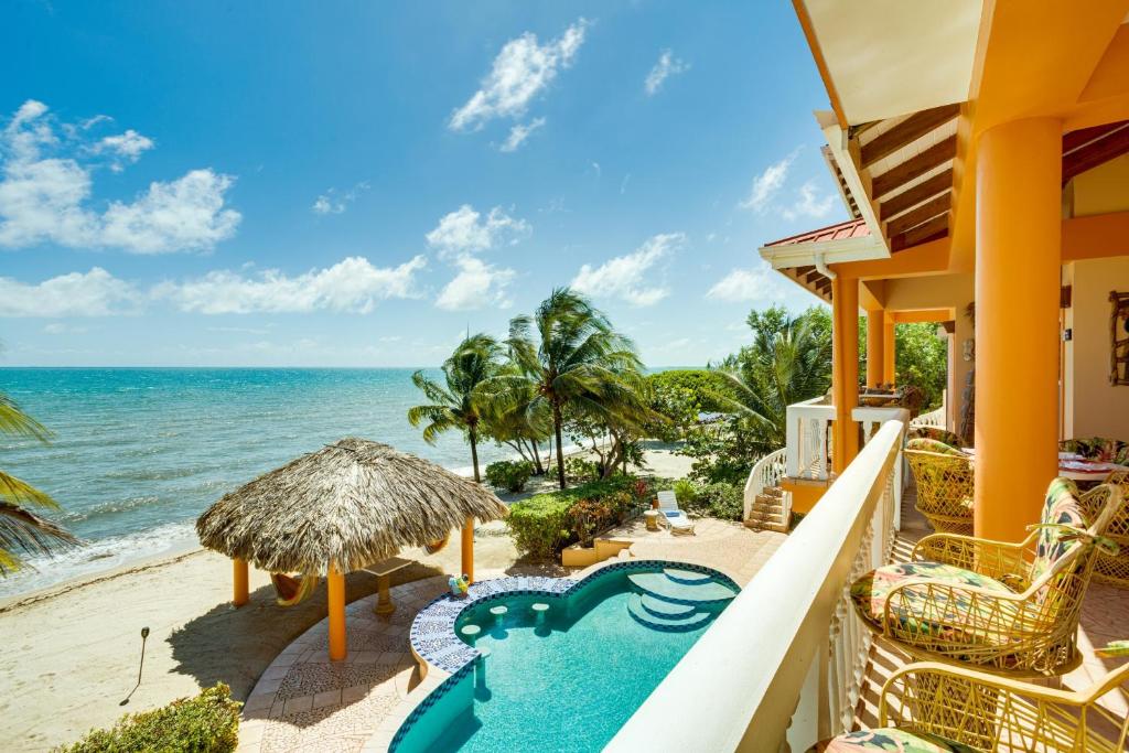 a view of the beach from the balcony of a resort at Villa 99-Beachfront-Pool-Luxury Villa in Placencia