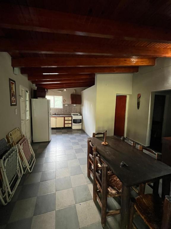 a kitchen with a table and a refrigerator in a room at Los Mimines in Potrero de los Funes