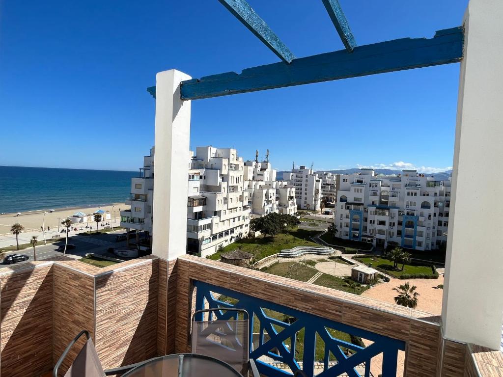 een balkon met uitzicht op het strand en de gebouwen bij Appartement City Jardin - Pied sur mer in Martil