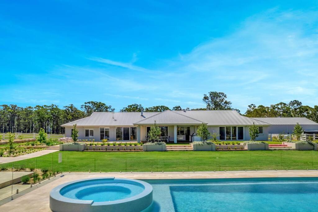 a house with a swimming pool in front of it at Luxury Hunter Valley Estate in Lochinvar