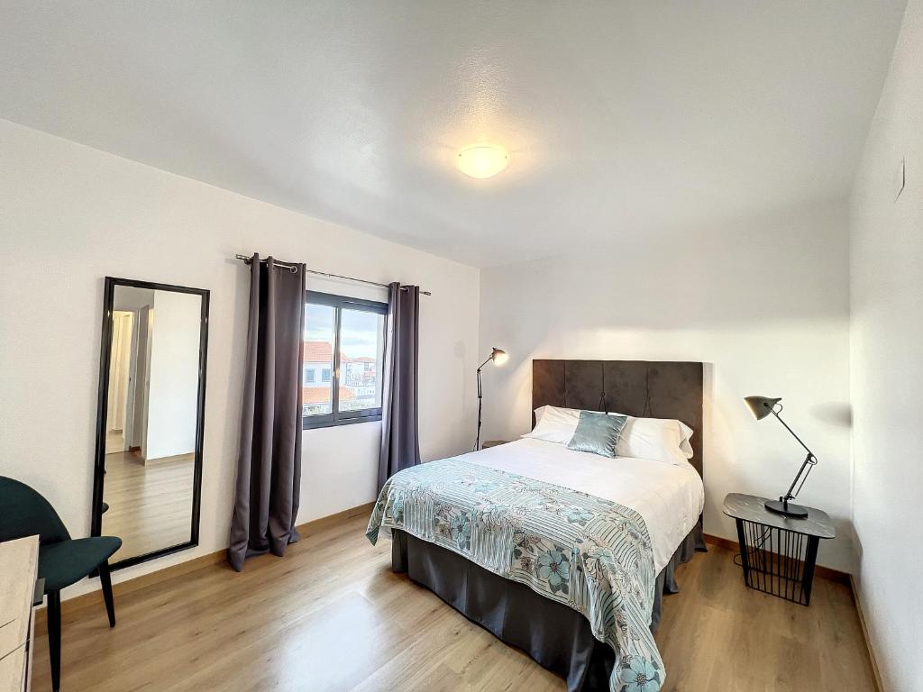 a bedroom with a bed and a large window at PIX Apartments in Madalena