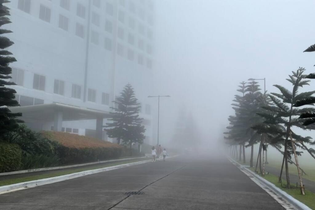 a person riding a bike down a street in the fog at Sevilla's Place in Tagaytay
