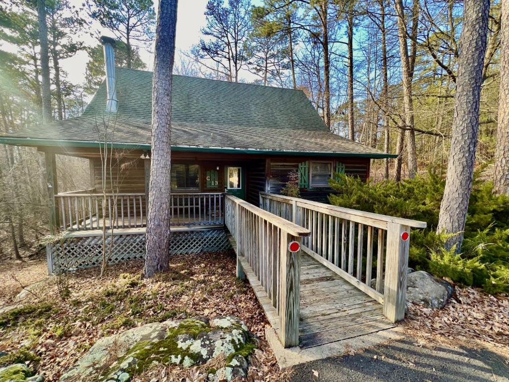 a small house with a wooden porch in the woods at C13 - Forest View two bedroom, two bath Harbor North luxury loft cottage with private hot tub o Lake on Ouachita in Mount Ida