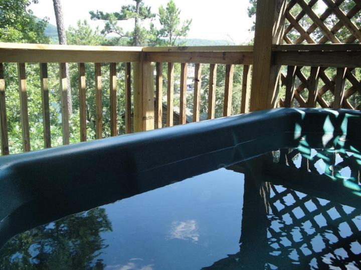 eine Bank mit einer Spiegelung in einem Wasserbecken in der Unterkunft C9, Two bedroom, two bath, log-sided, lake view cottage with hot tub cottage in Mount Ida