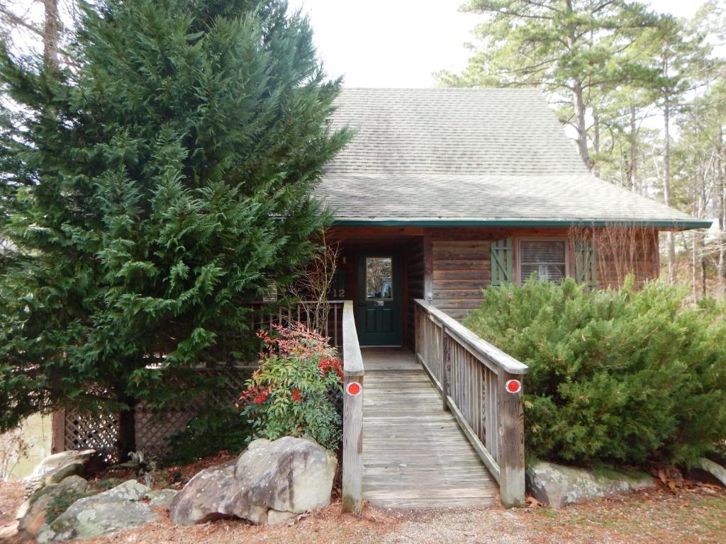 a cabin with a wooden staircase leading to a door at Luxury, loft, log-sided two bedroom Harbor North cottage cottage in Mount Ida