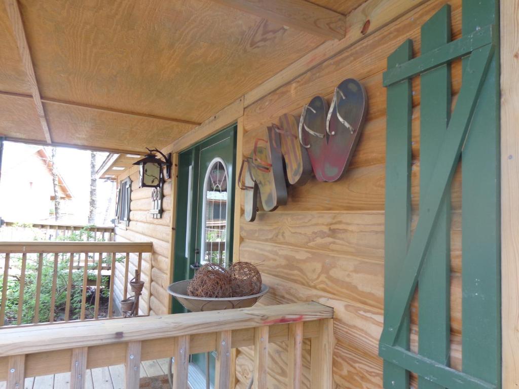 Cabaña de madera con porche con puerta verde en C23, Two bedroom, two bath log-sided, luxury Harbor North cottage with hot tub cottage, en Mount Ida