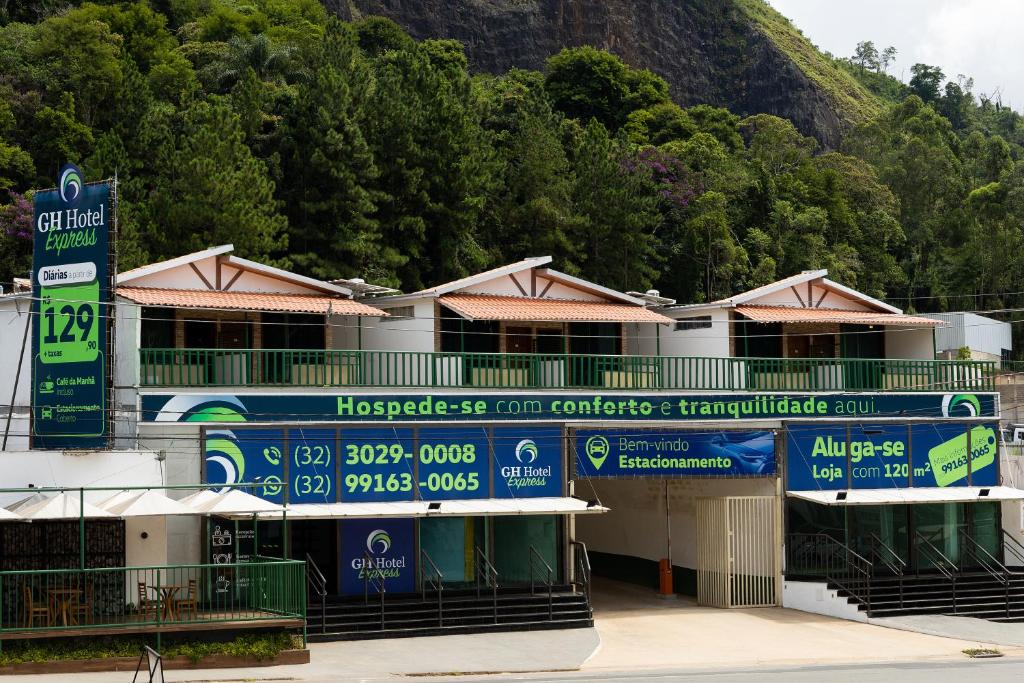 ein Gebäude mit Schildern an der Seite in der Unterkunft GH Hotel Express in Juiz de Fora