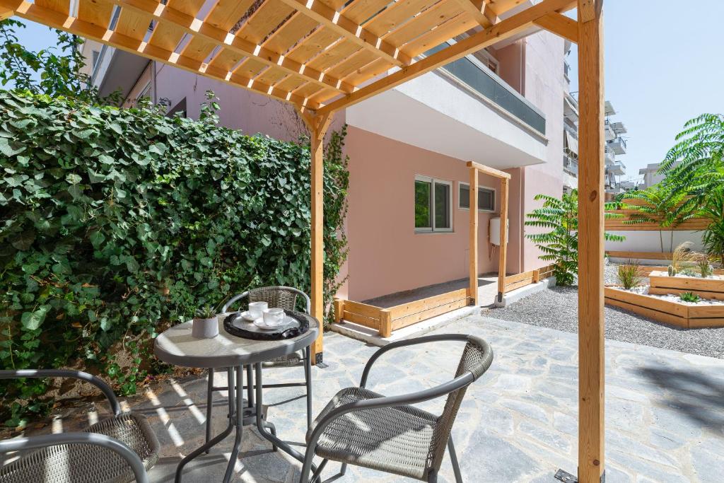 d'une terrasse avec une table et des chaises sous une pergola. dans l'établissement Άνετο διαμέρισμα με κήπο, à Rhodes