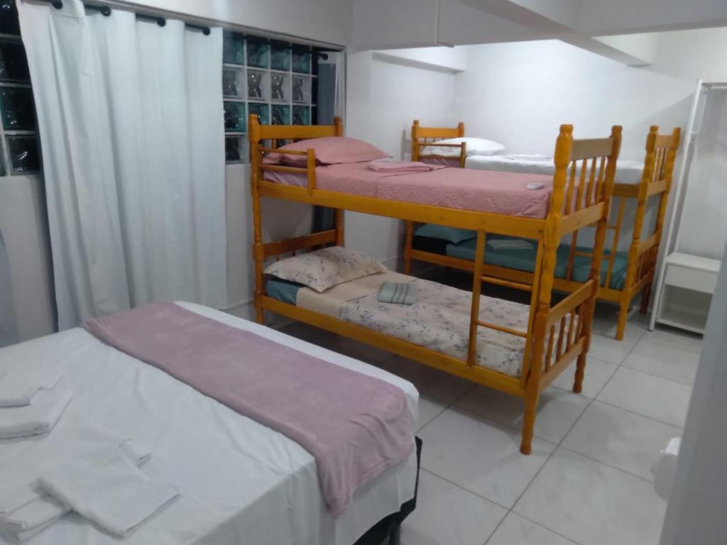 a bedroom with two bunk beds and a window at Pousada cafe com margarida 150 metros do mar rua do calçadao da central in Balneário Camboriú