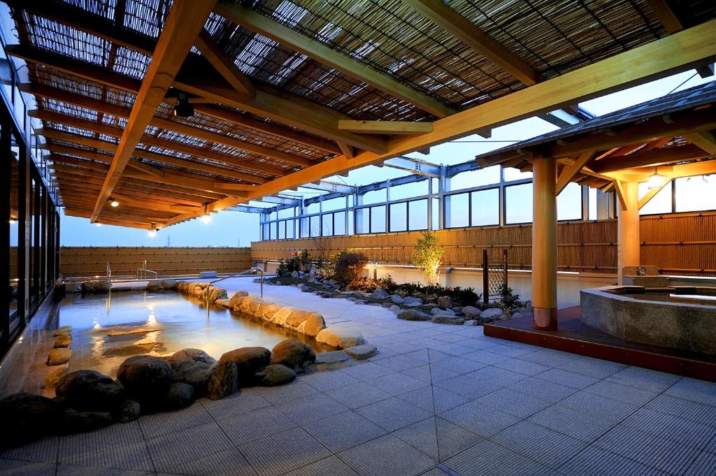 un grand bâtiment avec une piscine d'eau et des bûches. dans l'établissement Tokyo Yugawara Onsen Manyo no Yu, à Machida