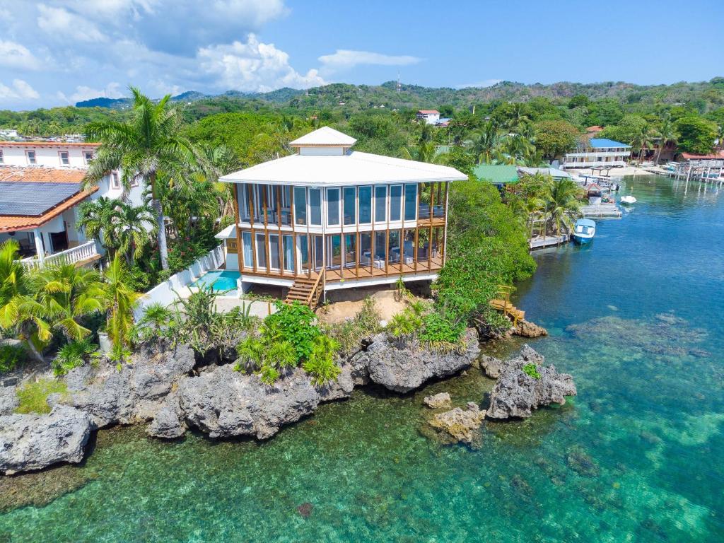 an aerial view of a house on a rock in the water at Wow! Views and more, fantastic 2 bedroom in West End - Villa Agua apts in Roatán
