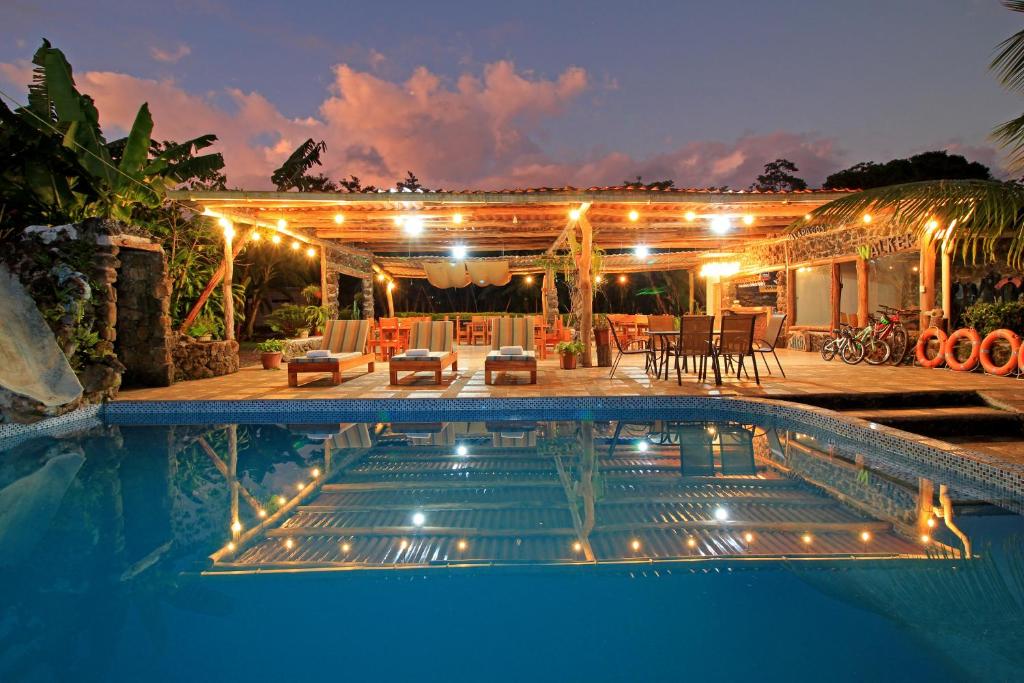 a swimming pool in front of a house with lights at Natura Gardens Galápagos in Bellavista