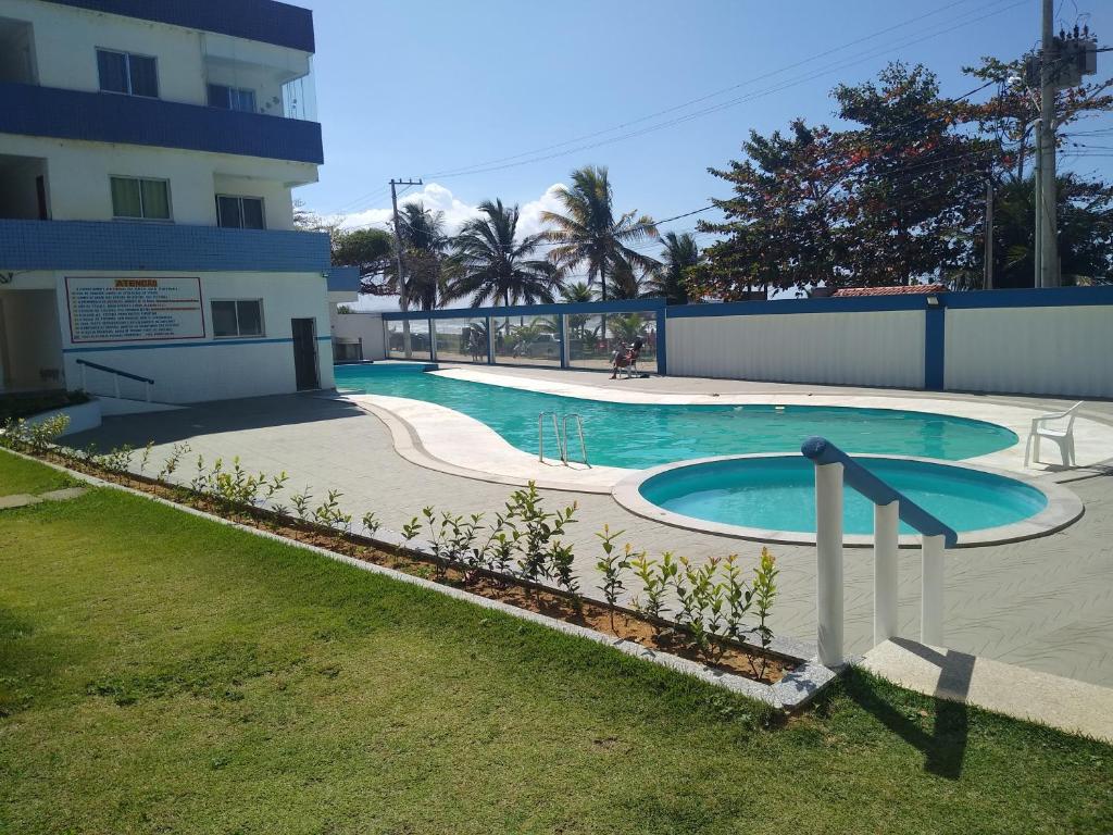 a swimming pool in front of a building at Cobertura vista para o mar e piscina in Piúma