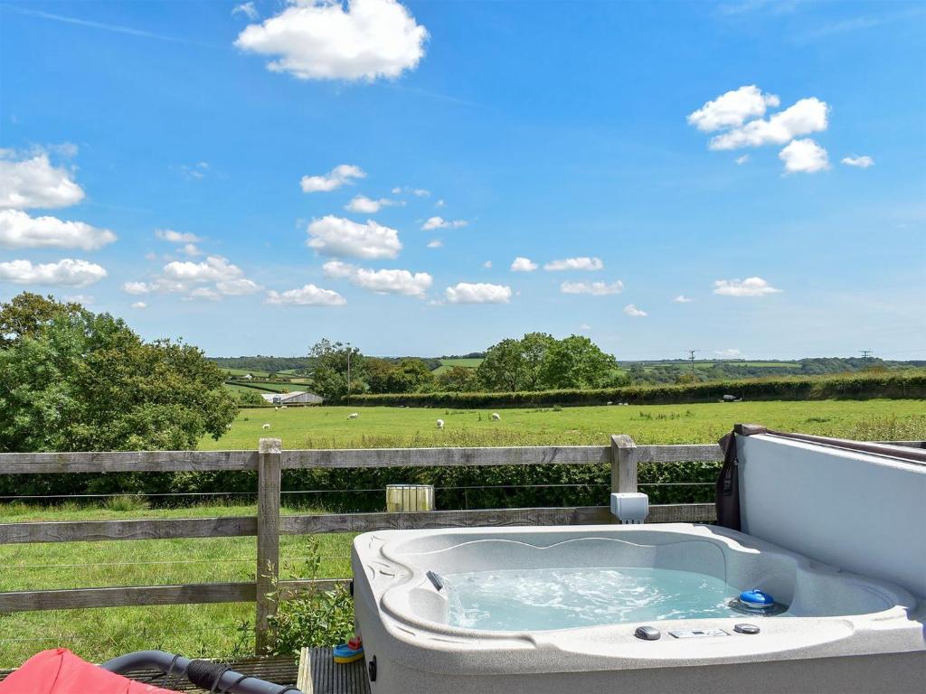 a bath tub with a view of a field at Rivendell Glamping Pod - Uk11881 in North Tamerton