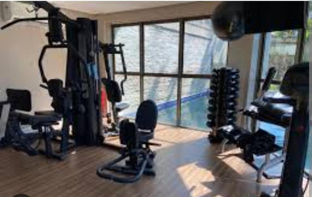 um ginásio com equipamento de exercício numa sala com janela em Samba convention suites no Rio de Janeiro