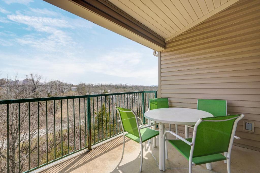 eine Terrasse mit einem Tisch und Stühlen auf dem Balkon in der Unterkunft Cozy Top Floor 2BR Condo with View and Amenities!! in Branson