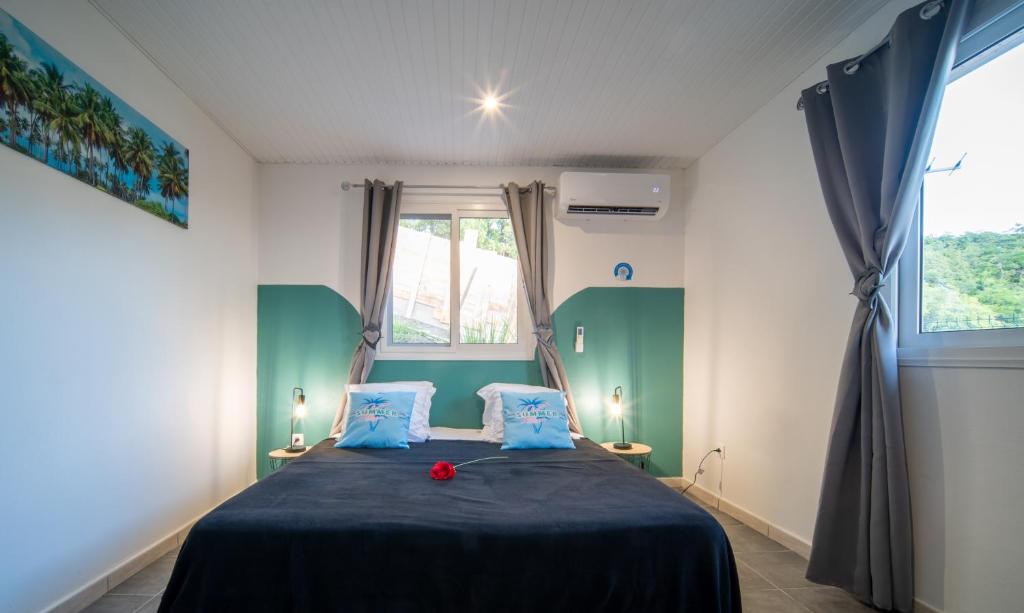 a bedroom with a bed with blue and green at La Perle du Cap in Case-Pilote