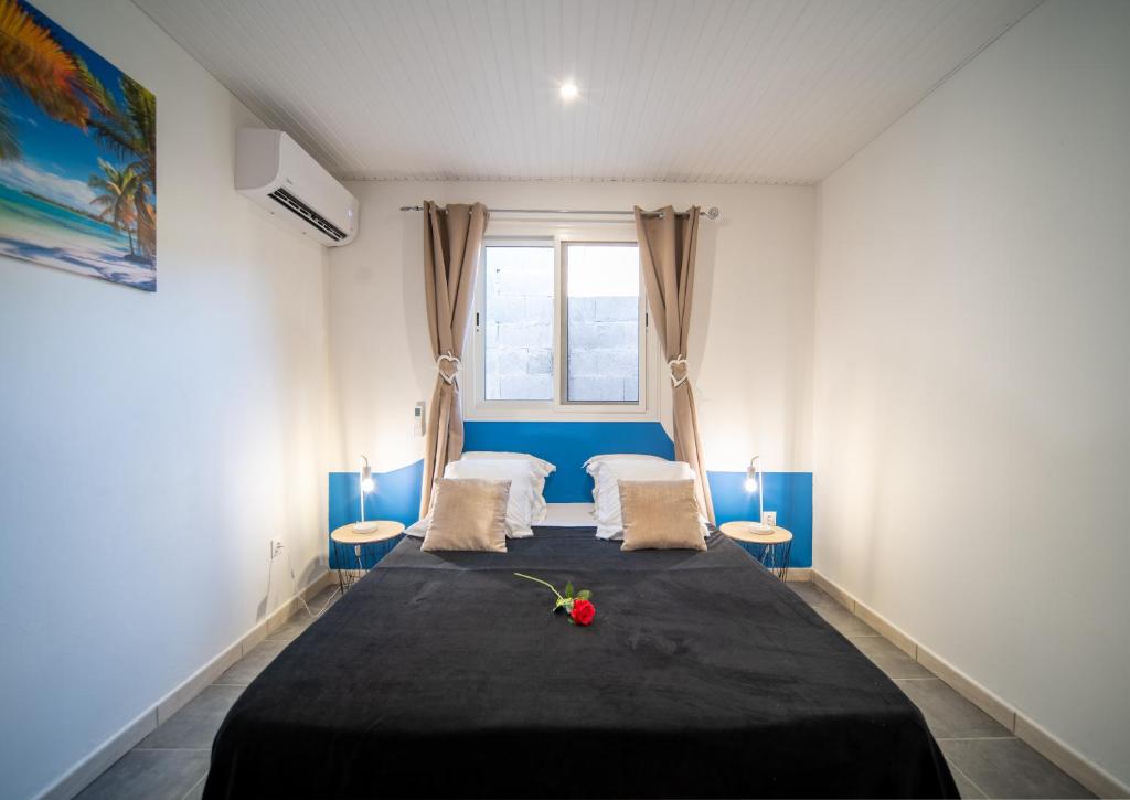 a bedroom with a bed with a black blanket at La Perle du Cap in Case-Pilote