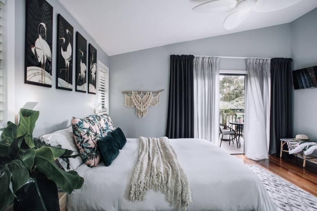 a bedroom with a white bed and a window at Palm House - by Coast Hosting in Terrigal