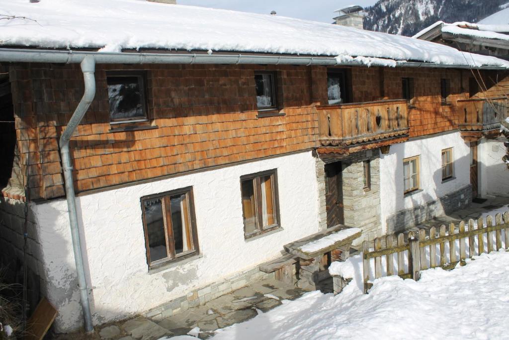 ein schneebedecktes Gebäude mit einem schneebedeckten Dach in der Unterkunft Knappenhaus in Rauris