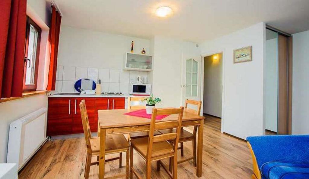 una cucina e una sala da pranzo con tavolo e sedie in legno di Apartamenty Motylem Jestem a Szczawnica