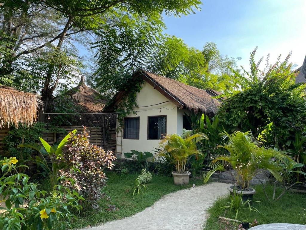 a small white house with a path in front of it at Tipsea Turtle Gili Air in Gili Air