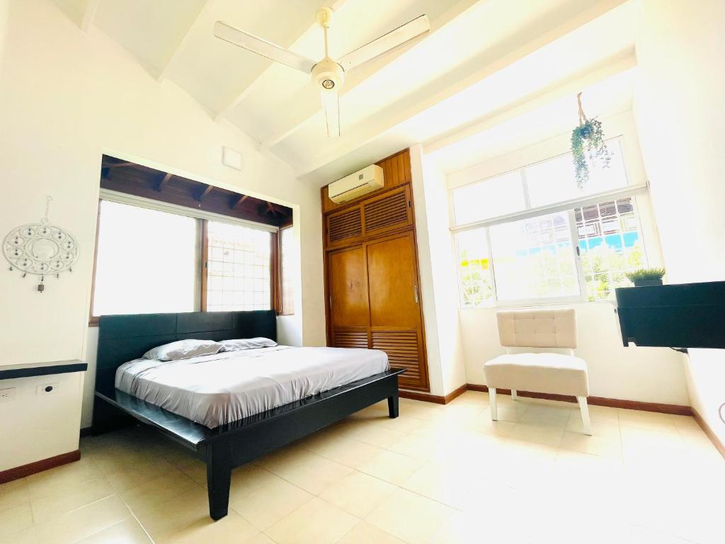 1 dormitorio con 1 cama y ventilador de techo en Uchuva beach house, en Santa Marta