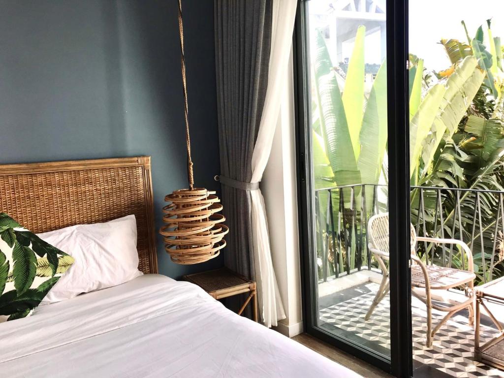 ein Schlafzimmer mit einem Bett neben einem Balkon in der Unterkunft Green River Boutique Hotel in Vũng Tàu