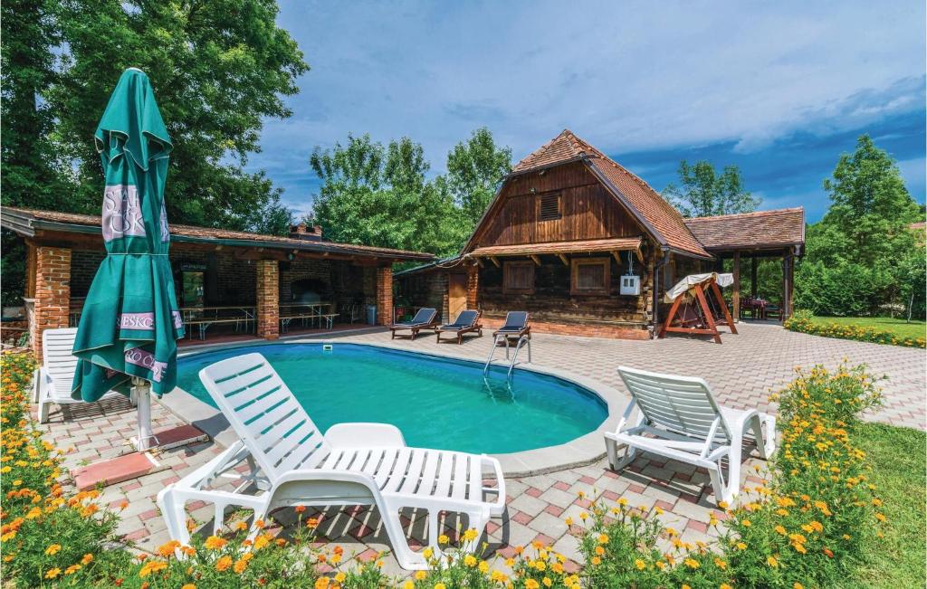a swimming pool with chairs and a house at 3 Bedroom Beautiful Home In Lekenik in Gračanica