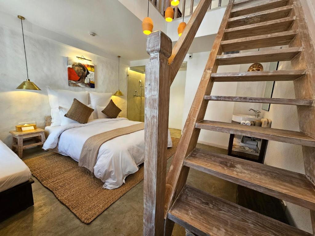 1 dormitorio con cama grande y escalera de madera en The Nanee, en Bhaktapur